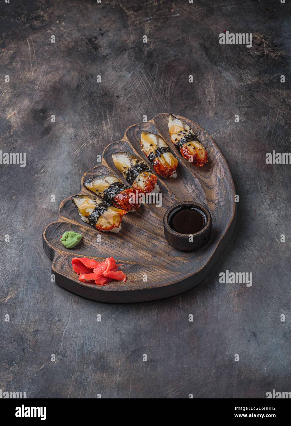Tavola di legno di sushi nigiri su sfondo nero Foto Stock