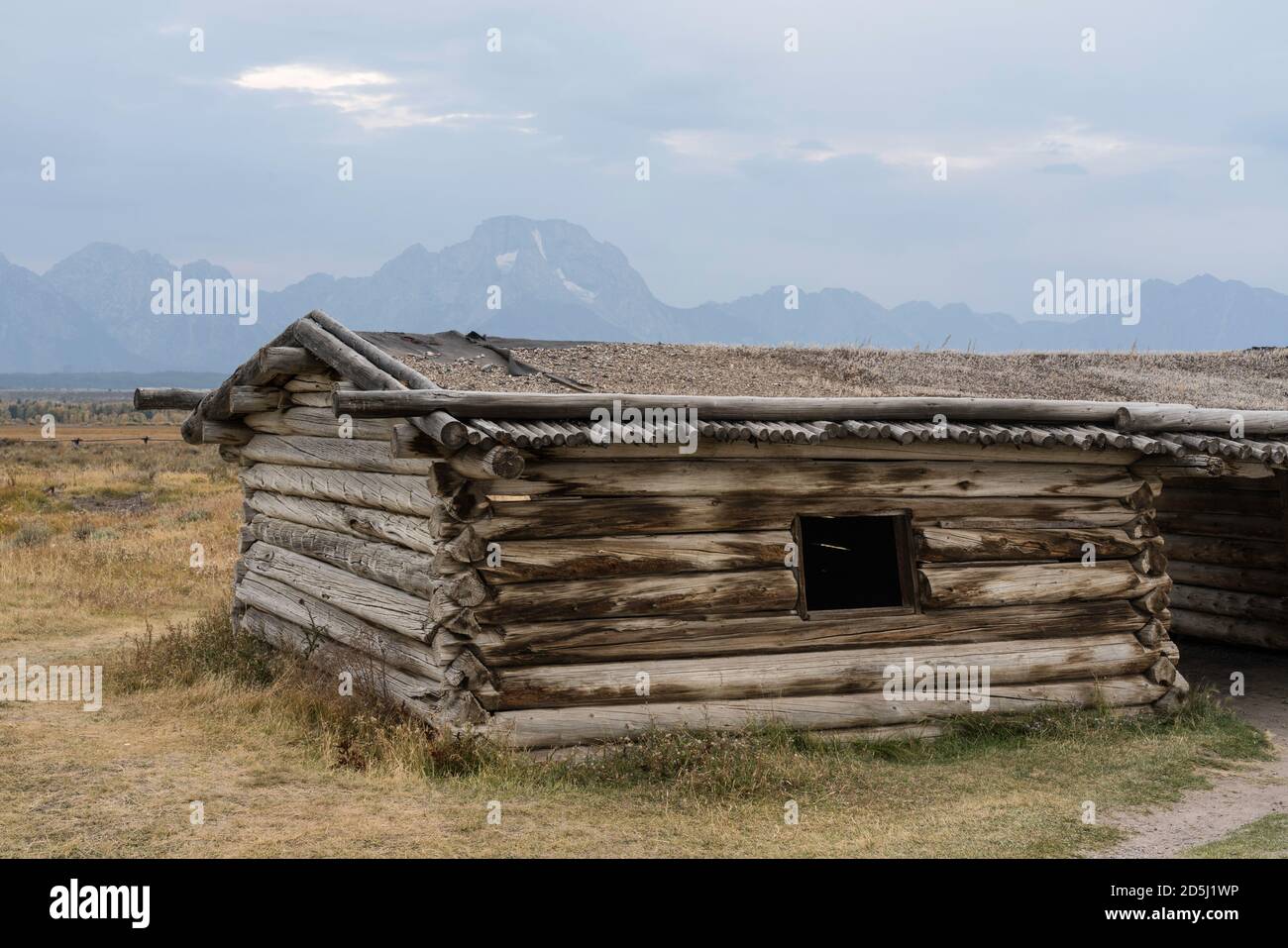 La vecchia cabina storica del ranch di Cunningham nel Grand Teton National Park fu costruita con tronchi da J.P Cunningham nel 1888. Dietro si trova il Monte Moran e il Teton Foto Stock