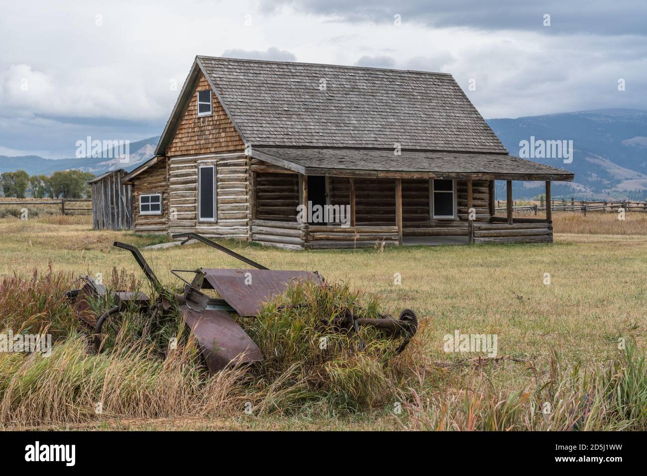 Vecchie macchine agricole e la casa di tronchi sulla casa Andy Chambers sulla Mormon Row nel Grand Teton National Park nel Wyoming, Stati Uniti. Foto Stock