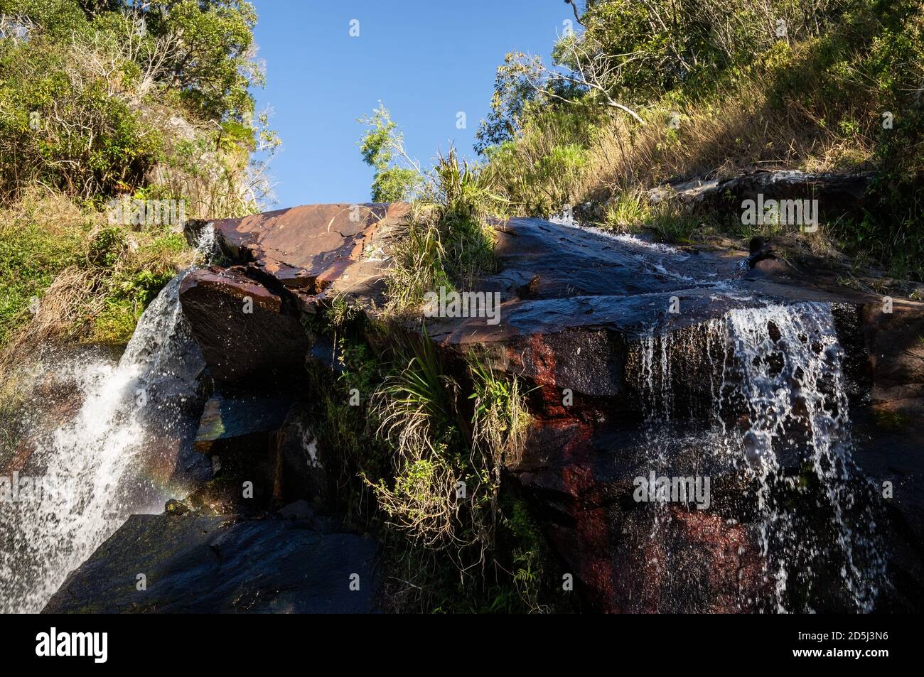 L'estremità superiore della cascata di Mato Limpo circondata da vegetazione verde con l'acqua cristallina che scorre e spruzzi sulle rocce. A cascata Foto Stock