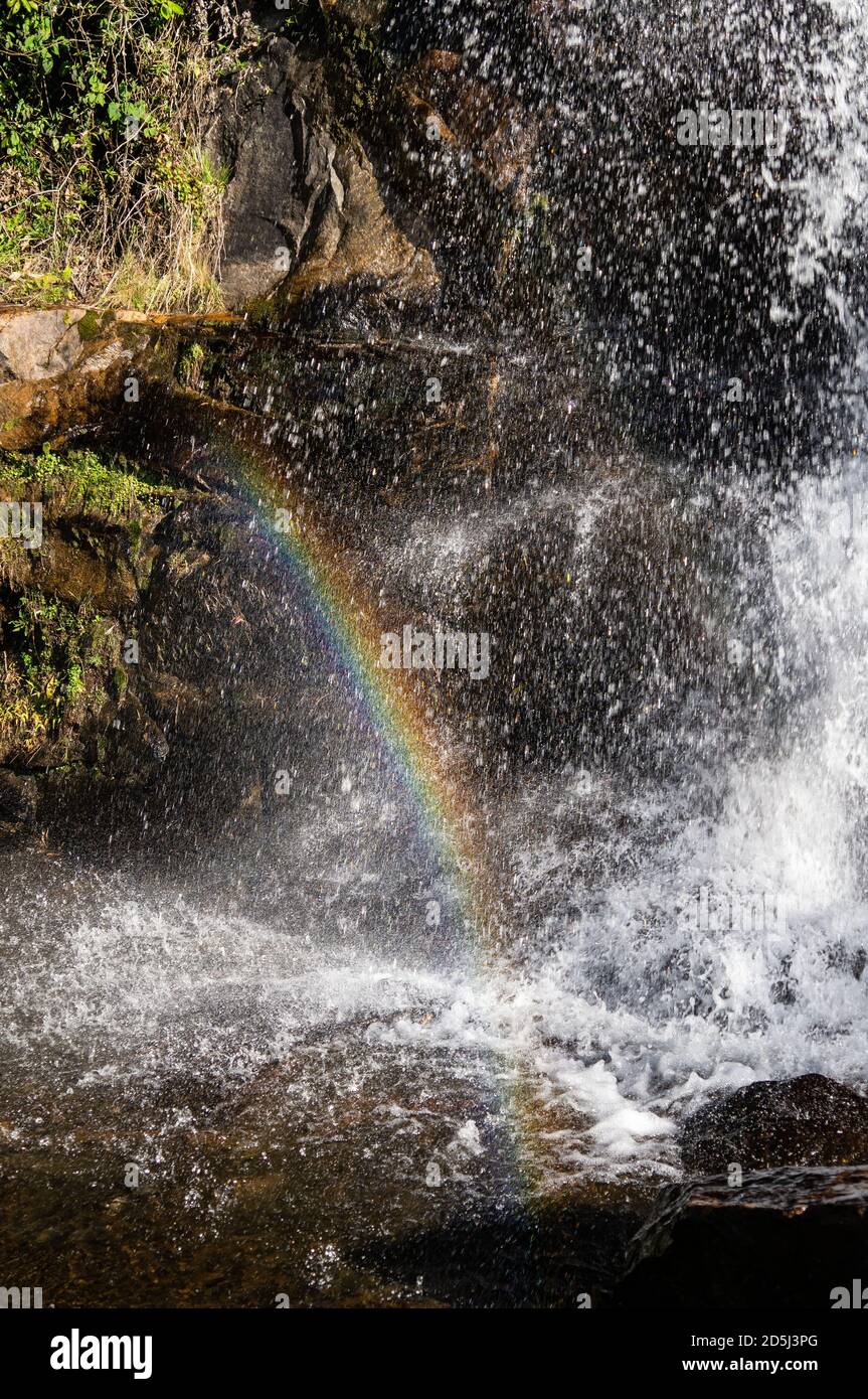 Vista ravvicinata della cascata di Mato Limpo, acque cristalline che si tuffano sulle formazioni rocciose e formano un arcobaleno nell'aria. Cunha, San Paolo - Brasile. Foto Stock