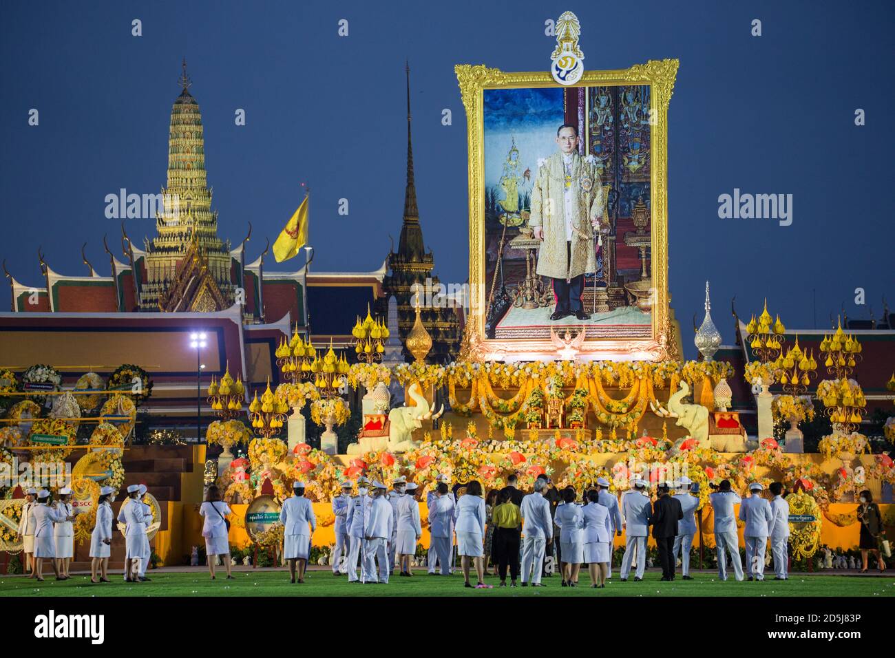 Bangkok, Thailandia. 13 ottobre 2020. Funzionari thailandesi si levano in piedi davanti ad un grande ritratto del defunto re tailandese Bhumibol Adulyadej (Rama 9) durante la cerimonia del quarto anniversario della sua morte. Credit: SOPA Images Limited/Alamy Live News Foto Stock