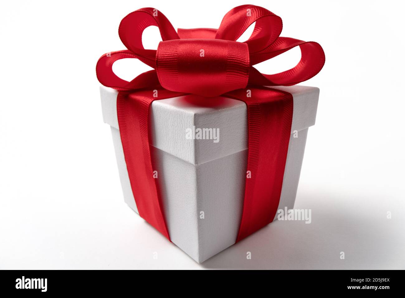 Scatola regalo bianca con un nastro rosso bow, isolato su bianco Foto Stock