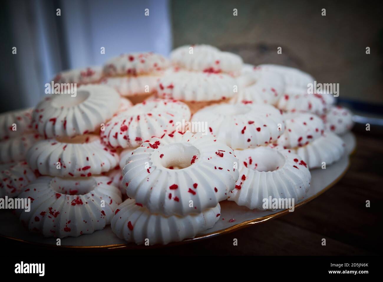 Sfondo di meringhe bianche con pasta frolla rossa crumb spruzzare Foto Stock