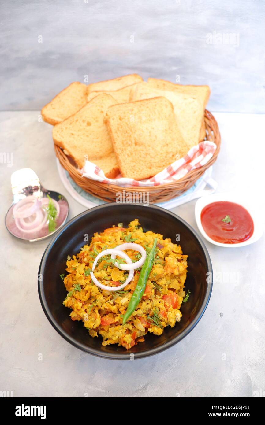 Piatto indiano per la colazione - Parsi Akuri o Anda Bhurji o uova strapazzate speziate indiane servite con pane marrone tostato e ketchup. Famoso cibo di strada indiano Foto Stock