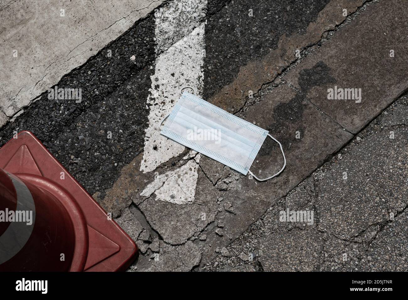 La maschera chirurgica usata è stata lasciata sulla strada Foto Stock