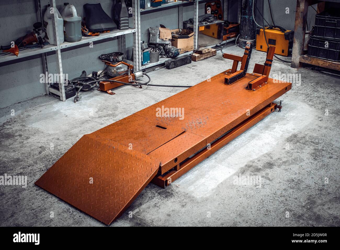 All'interno di un'officina di ascensore motociclistico per la manutenzione e la riparazione di motocicli da vicino. MotoService con rack e strumenti per Mending.Garage con un w Foto Stock