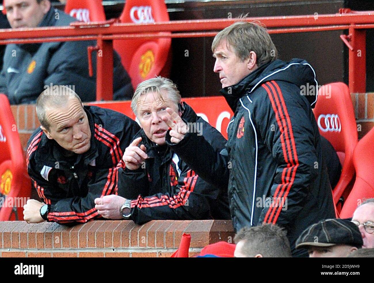Il manager di Liverpool Kenny Dalglish (a destra) discute le tattiche con il suo assistente Sammy Lee (al centro) dalla panchina Foto Stock