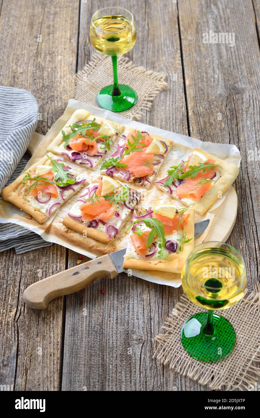 Tarte Flambee dall'Alsazia con salmone affumicato e foglie di razzo Servito con vino bianco locale alsaziano Foto Stock