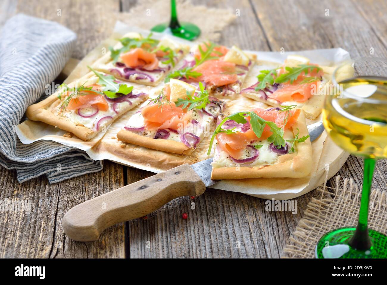 Tarte Flambee dall'Alsazia con salmone affumicato e foglie di razzo Servito con vino bianco locale alsaziano Foto Stock