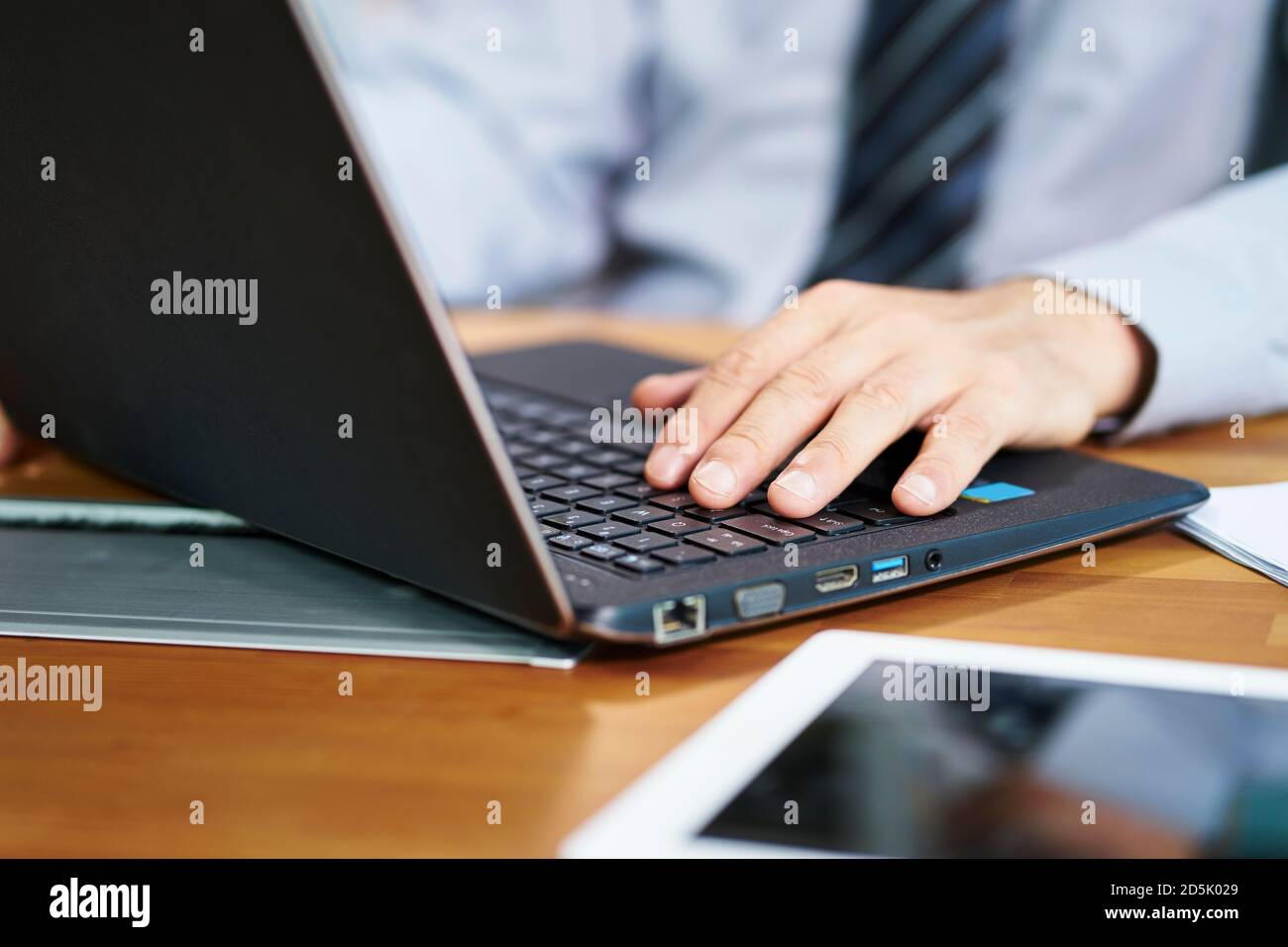 primo piano di mano di un uomo d'affari asiatico che lavora in ufficio utilizzando un computer portatile Foto Stock