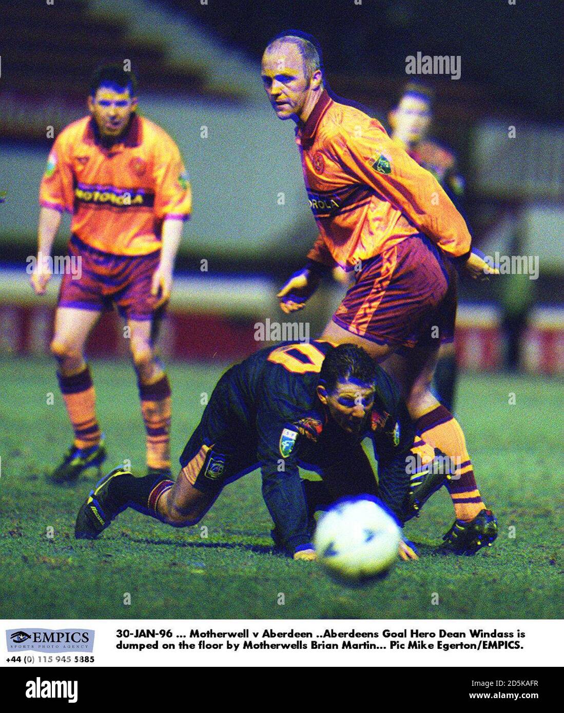 30-GEN-96 ... Motherwell v Aberdeen ..Aberdeens obiettivo Hero Dean Windass è scaricato sul pavimento da Motherwells Brian Martin Foto Stock