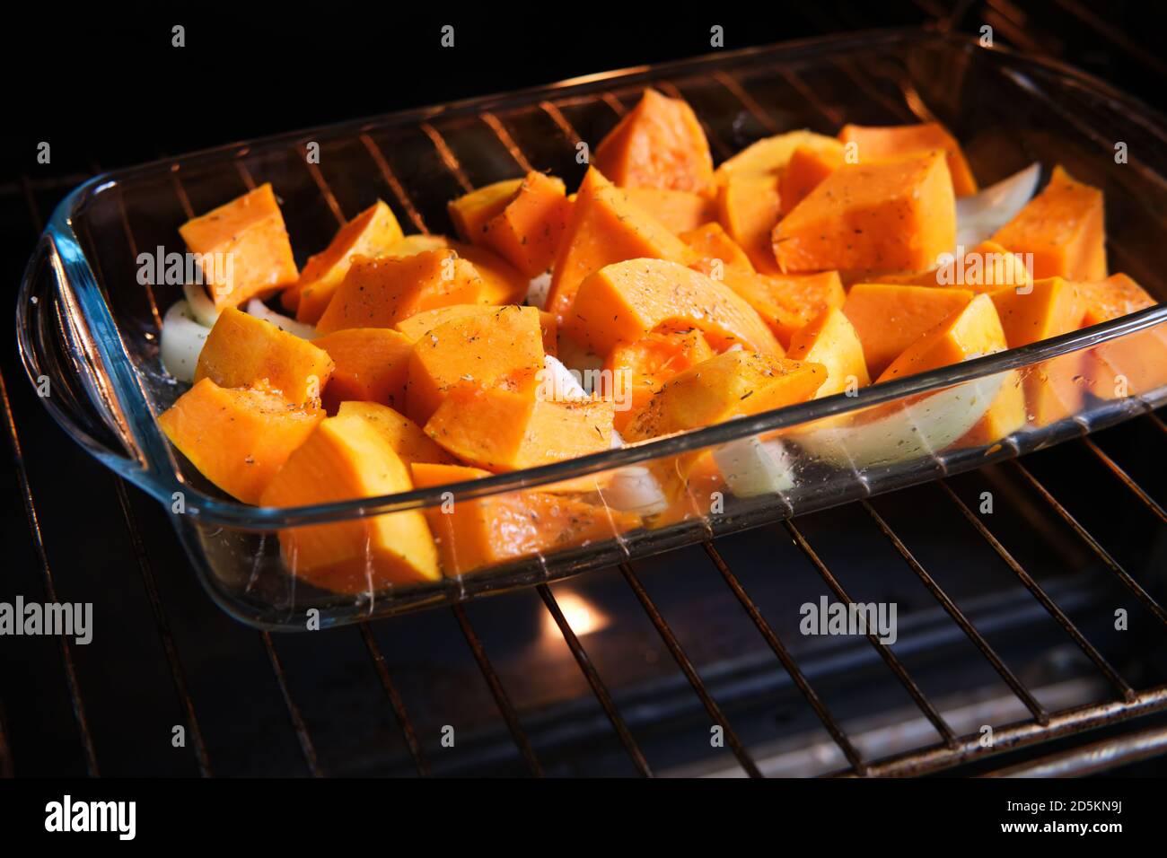 Cucinare la zucca piccante in un forno elettrico. Fette di zucca preparate per tostare in una teglia da forno Foto Stock