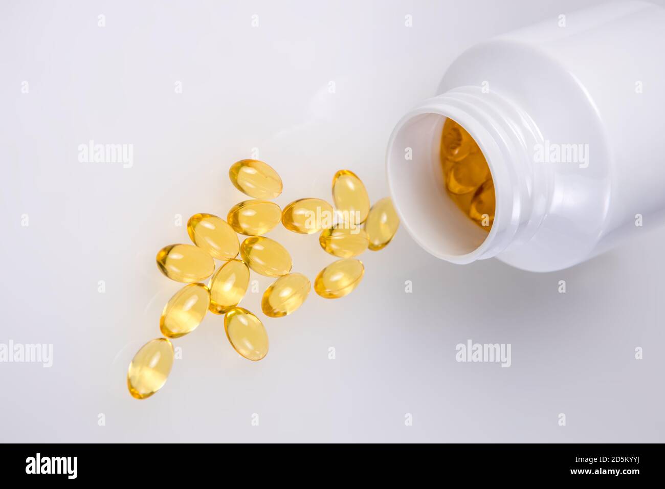 Capsule di vitamina D sparse su sfondo bianco. Additivo alimentare Foto Stock