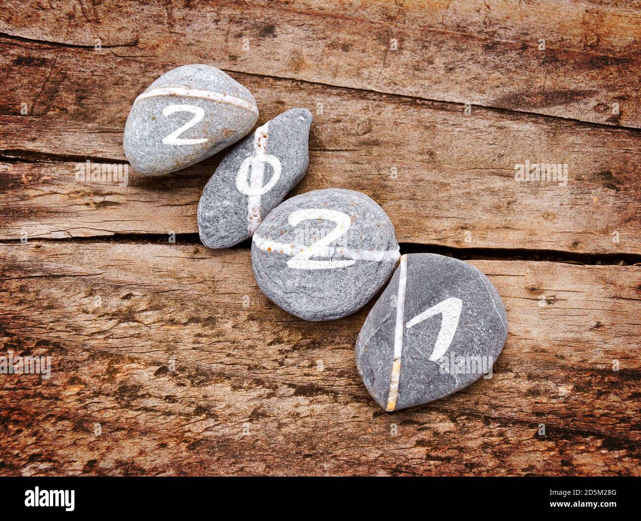 2021 scritto su una linea di pietre su sfondo ligneo, zen e la carta del nuovo anno della natura Foto Stock