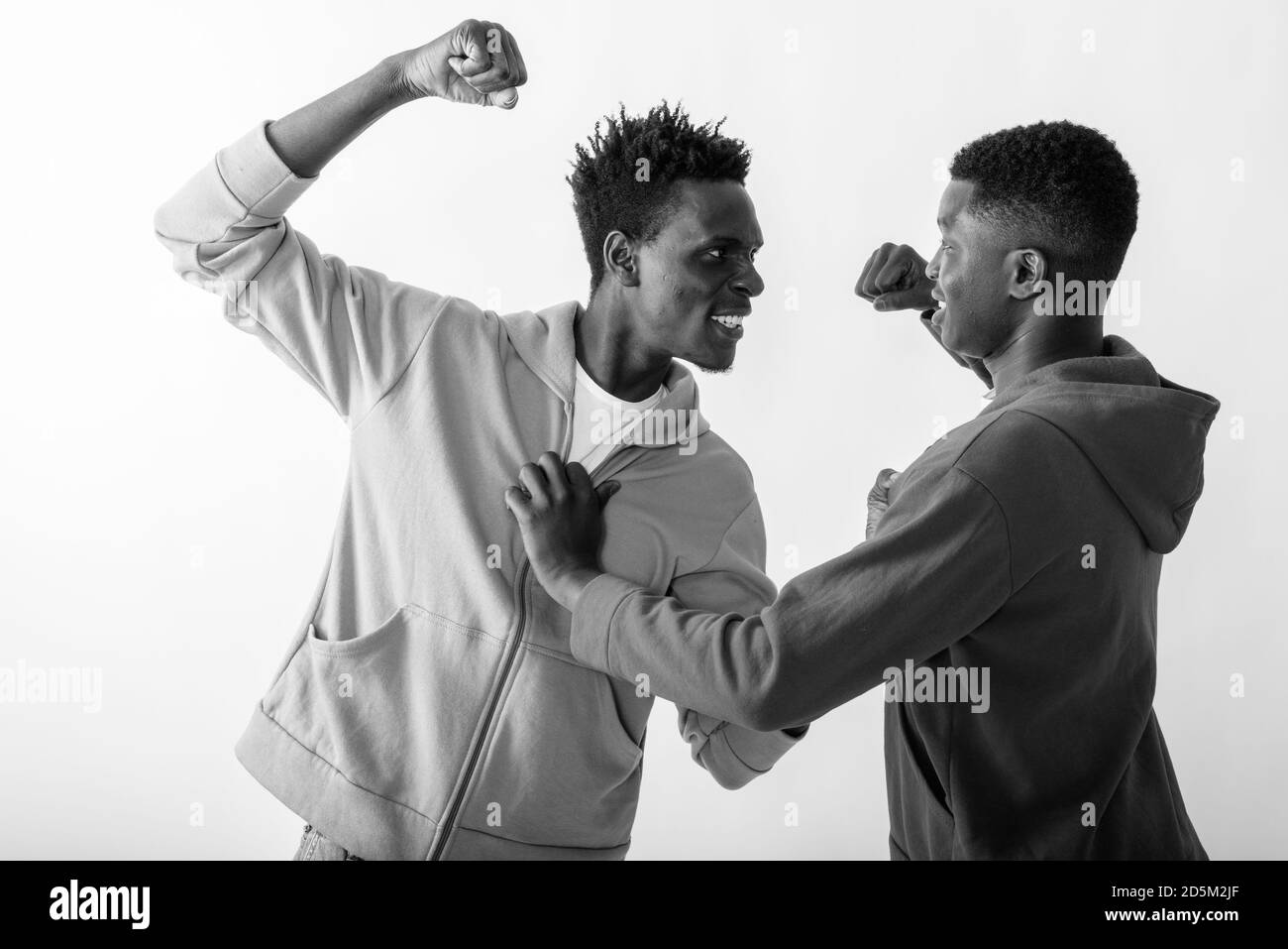 Studio shot di due giovani neri africani amici combattono contro uno sfondo bianco Foto Stock