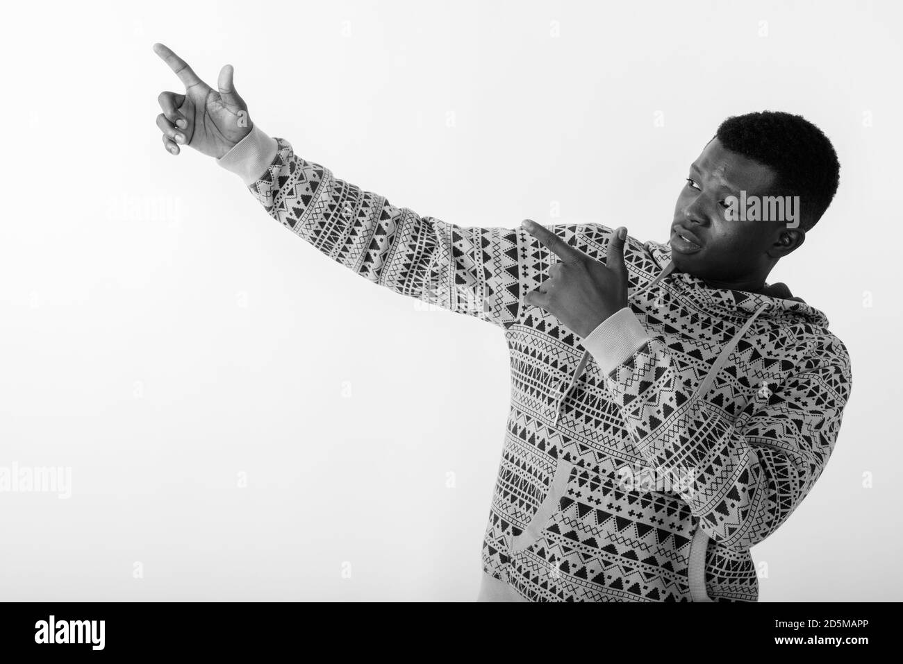 Studio shot del giovane nero africano puntando entrambe le dita in su contro uno sfondo bianco Foto Stock