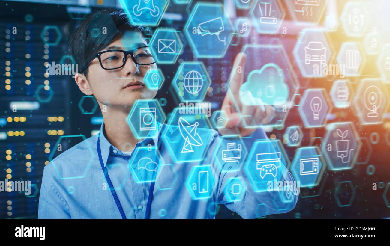 Immagine di un tecnico IT asiatico che lavora in una sala server per data center e tocca l'icona del cloud. Concetto di interfaccia utente cloud con computer diversi Foto Stock