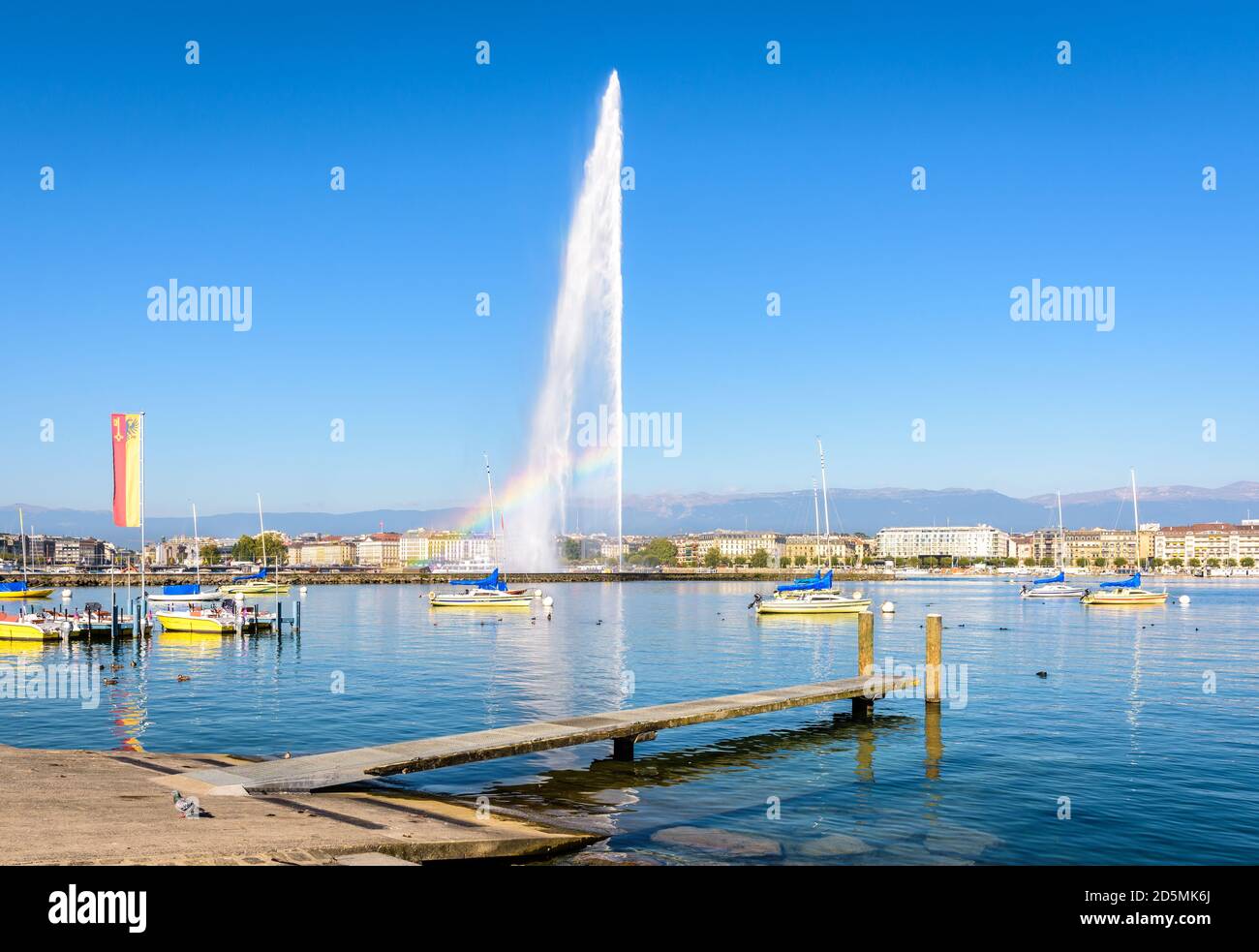 La baia di Ginevra in una soleggiata mattina estiva con un arcobaleno che appare sul Jet d'Eau, la fontana a getto d'acqua alta 140 metri sul Lago di Ginevra. Foto Stock