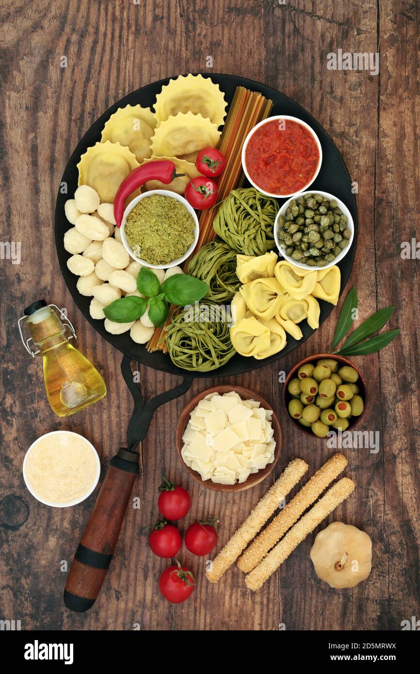 Cibo fresco per un pasto tipicamente italiano con una selezione di pasta e ingredienti sani su legno rustico. Alto in antiossidanti, antocianine, licopeni, Foto Stock