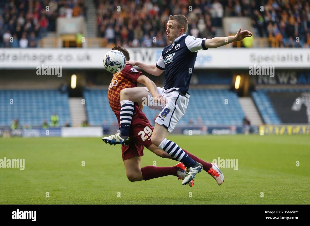 La battaglia di Shane Ferguson di Millwall e Tony McMahon di Bradford City (a sinistra) per la sfera Foto Stock