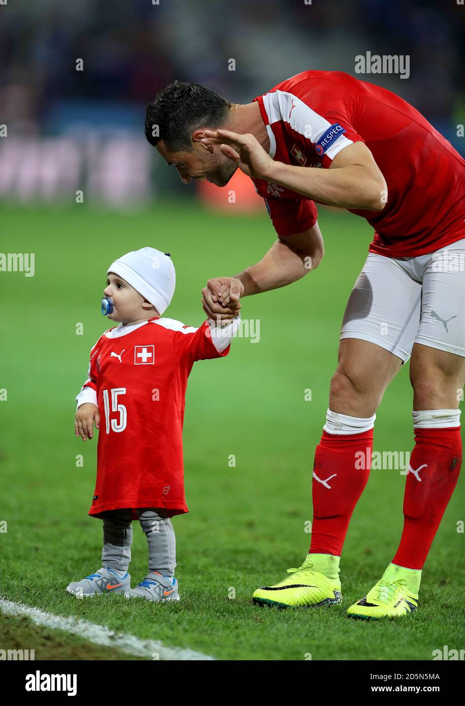 Blerim Dzemaili della Svizzera con suo figlio Luan sul campo dopo la partita. Foto Stock