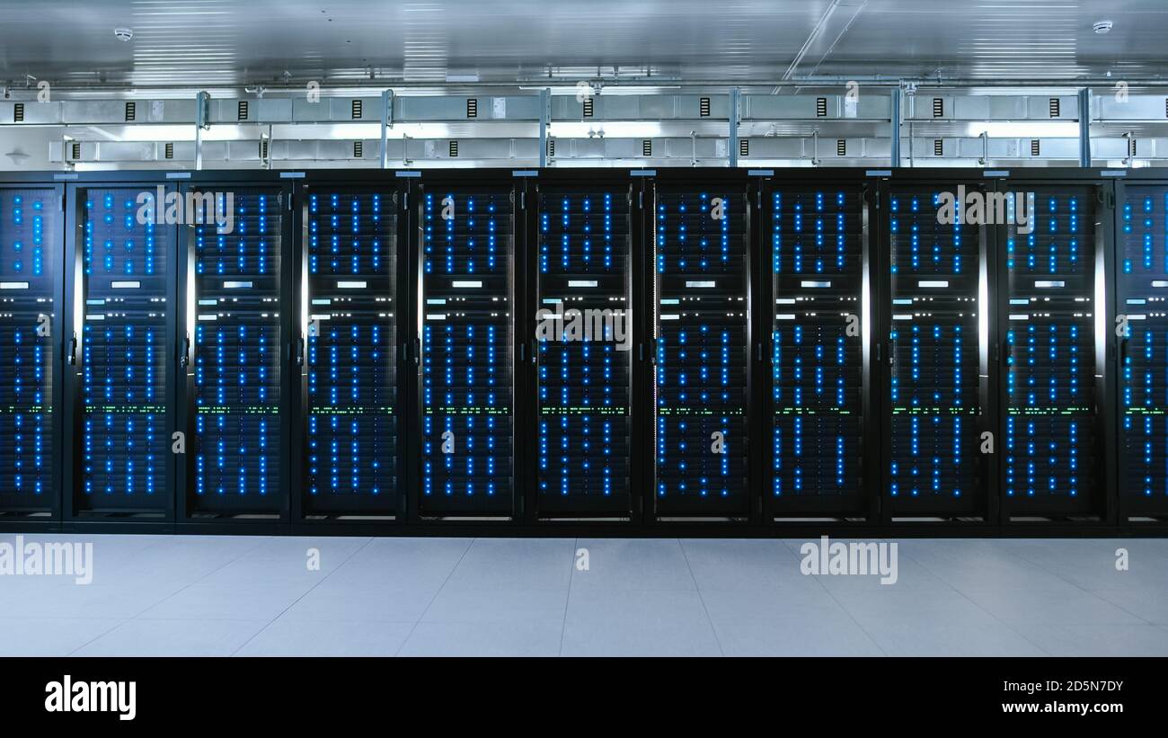 Immagine di un data center funzionante con file di server rack. Le spie LED lampeggiano e i computer funzionano. Foto Stock
