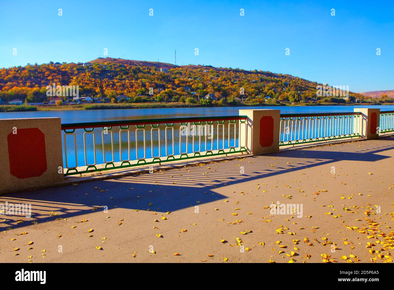 Foglie d'autunno sul lungomare con balaustra Foto Stock