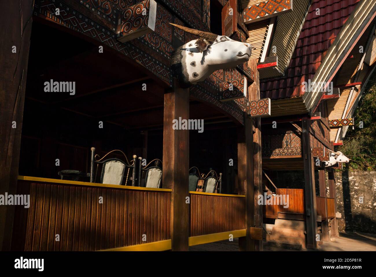 Vista orizzontale di due tongkonan splendidamente decorati con teste di bufalo, in legno dipinto e corna reali, appesi nel villaggio di Ma'dong, Tana Toraja Foto Stock