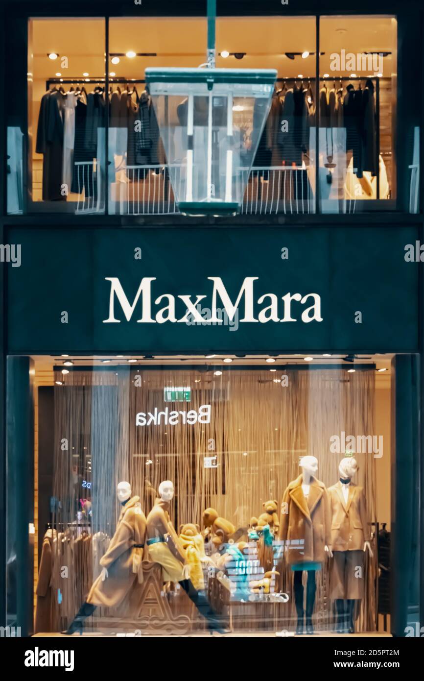Max Mara logo e vetrina del negozio di notte. Quattro manichini in piedi in vetrina. Abiti alla moda in boutique. Bergamo, Italia - Foto Stock