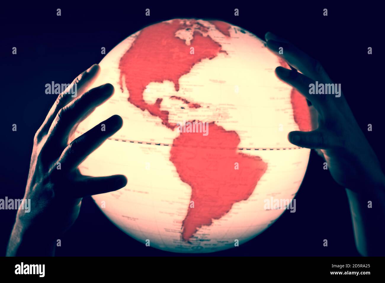 Mani che tengono un globo con continenti rossi Foto Stock