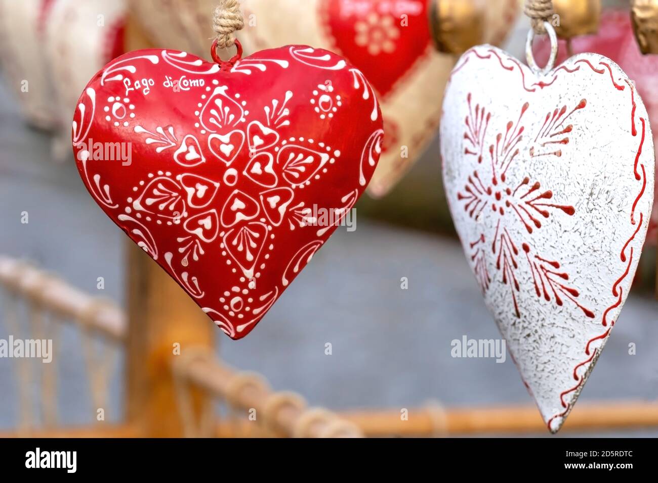 Cuore ricordo. Tradizionali campane di mucca alpine a forma di cuore sul mercato di strada. Il testo sul cuore significa Lago di Como Foto Stock