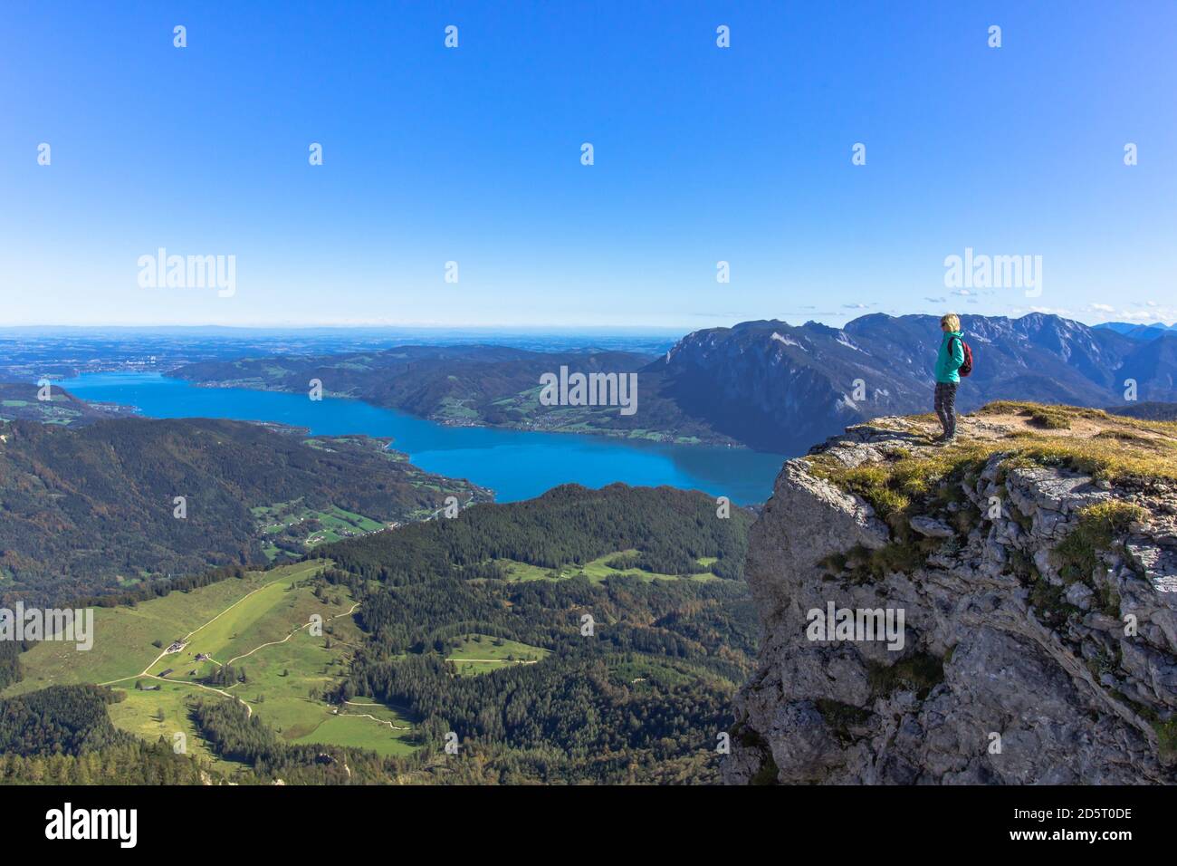 Ragazza attiva che riposa sulla cima delle Alpi, Austria.Backpacker godendo di vista del panorama di montagna e Lake.Hiking su luminoso sole day.Wander estate Foto Stock