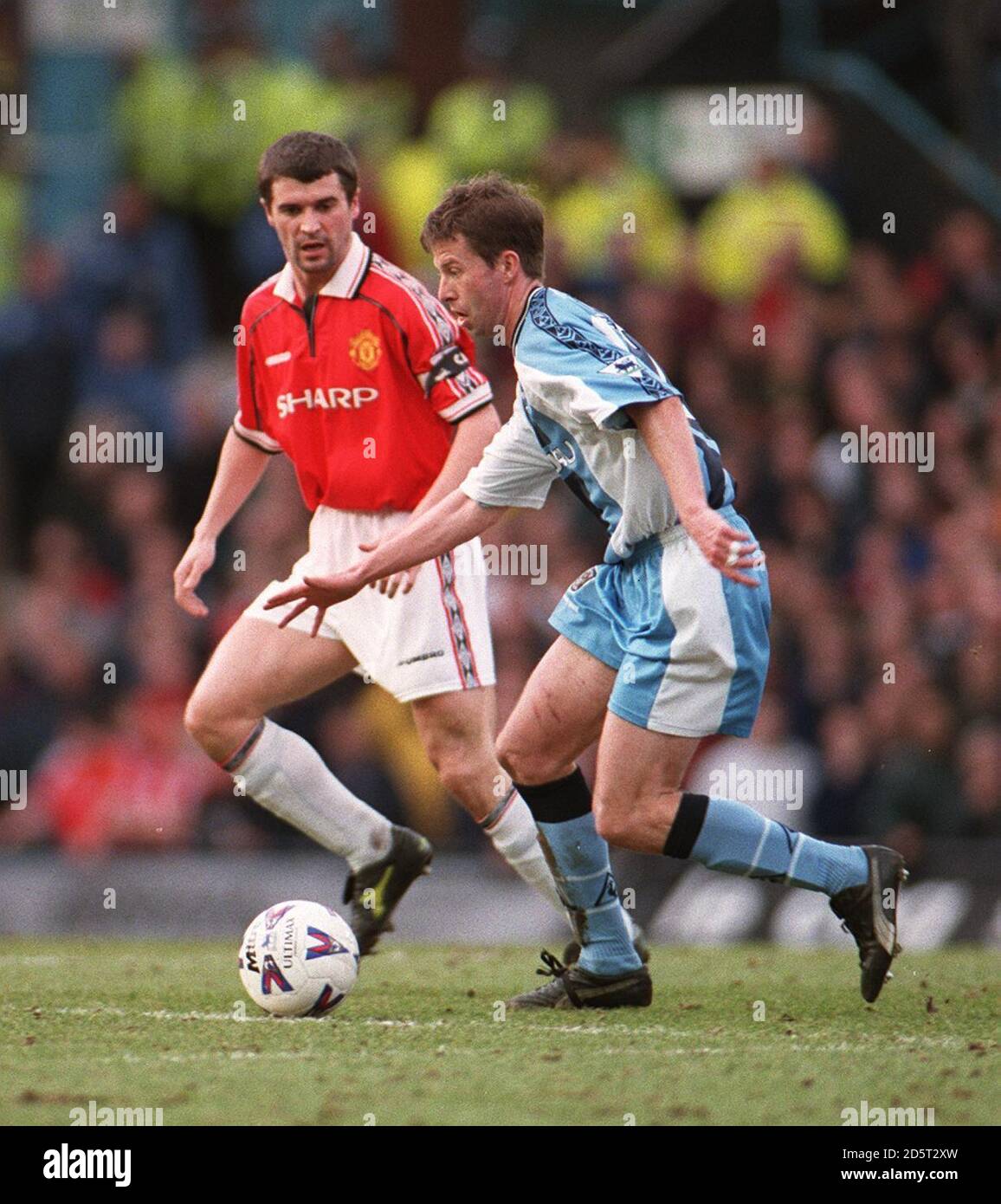 Stephen Froggatt di Coventry City passa accanto al Roy Keane di Manchester United Foto Stock