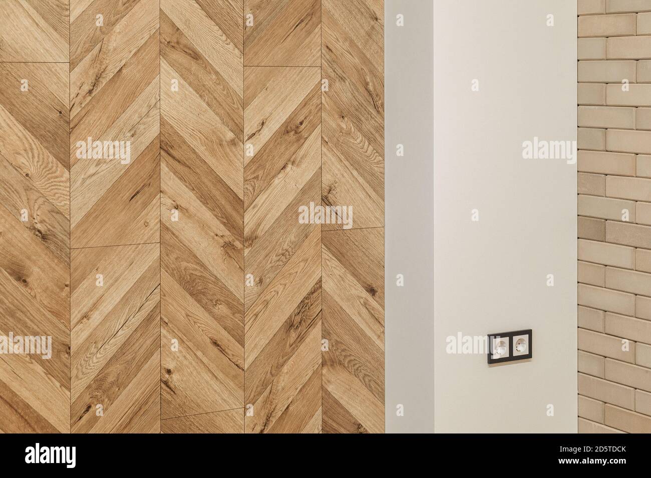 parte del soggiorno in colori caldi con una parete di finitura che imita parquet di legno, muro di mattoni Foto Stock