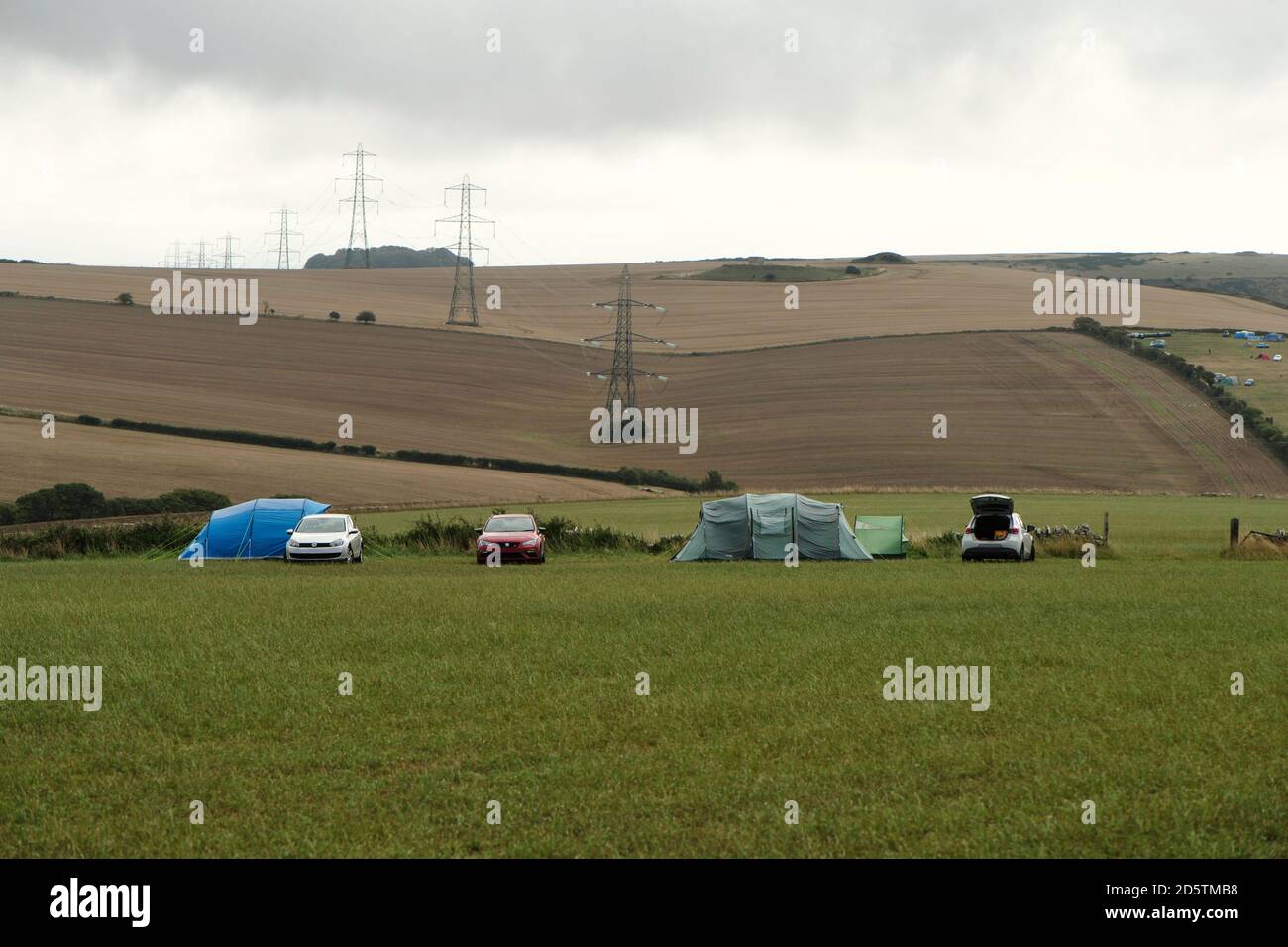 Due tende in campo con auto socialmente distanziate per una pausa di blocco. Tra due diversi amici di famiglia. Foto Stock