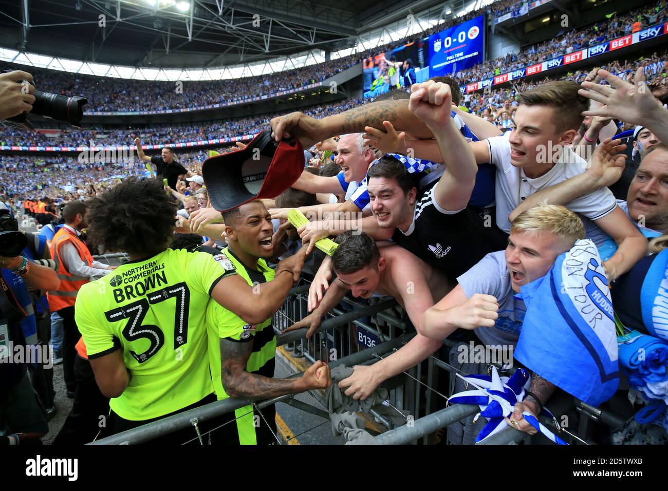 Isaiah Brown di Huddersfield Town festeggia con i tifosi dopo aver vinto il Sky Bet Championship Gioca alla finale Foto Stock