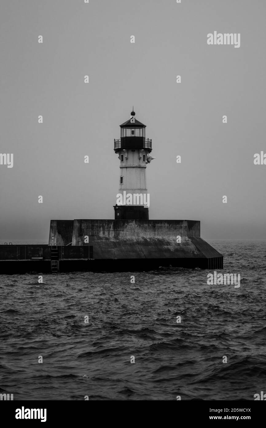 Faro catturato attraverso la nebbia, sulle onde a Duluth, Minnesota Foto Stock
