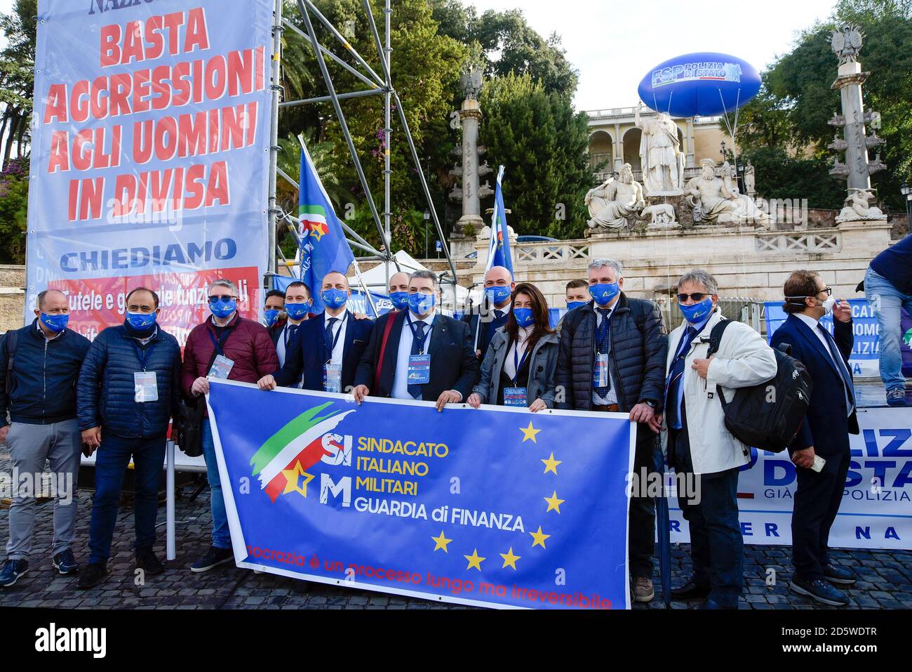 Durante la manifestazione, il protestore ha in mano una bandiera del sindacato della polizia finanziaria (SIM) in Piazza del Popolo. Dimostrazione unificata dei sindacati delle forze di polizia italiane per chiedere una maggiore protezione, un piano straordinario di hirings e un dignitoso aumento contrattuale per l'applicazione della legge. Foto Stock