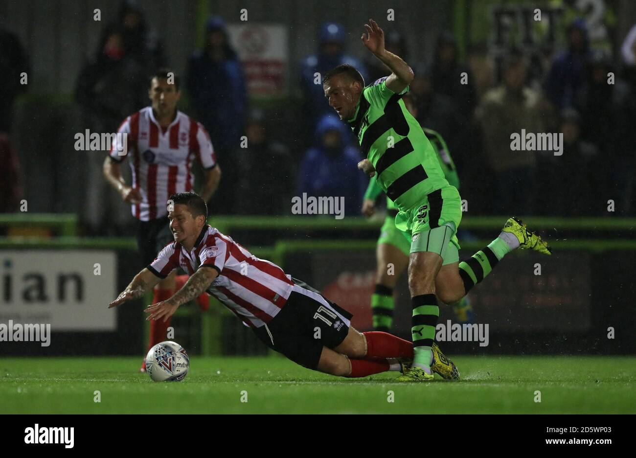 Il Billy Knott di Lincoln City è portato giù da Forest Green Lee Collins di Rovers Foto Stock