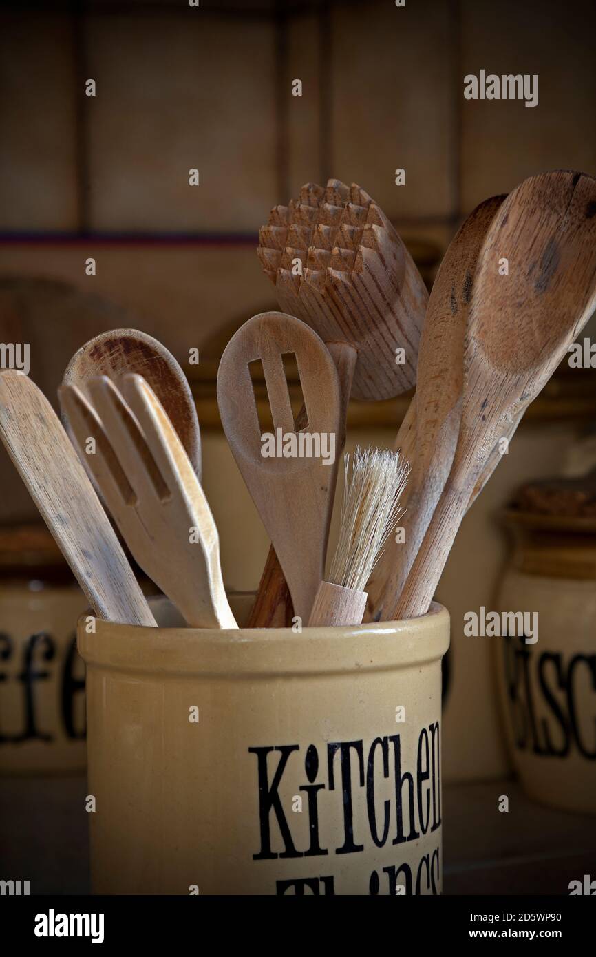 Utensili da cucina in legno e vasetti di stoccaggio retrò e ben utilizzati in cucina, con closeup in luce naturale Foto Stock