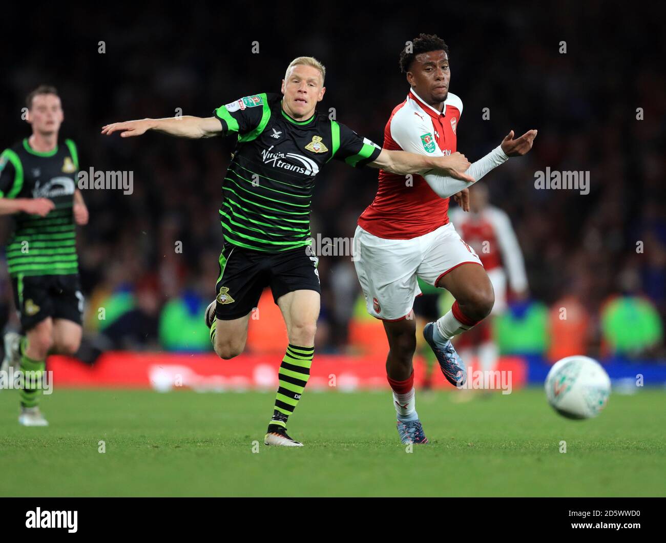 Alex Iwobi dell'Arsenal (a destra) e Craig Alcock di Doncaster Rovers (a sinistra) combatti per la palla Foto Stock