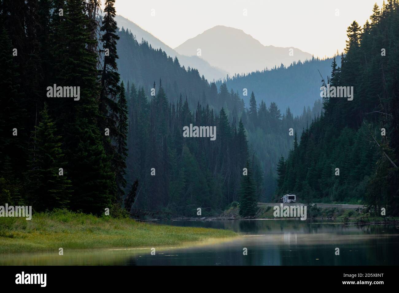 Scenario del lago Duffey con acque calme sullo sfondo di Boschi di conifere e silhouette di montagne nella Columbia Britannica in mattina Foto Stock