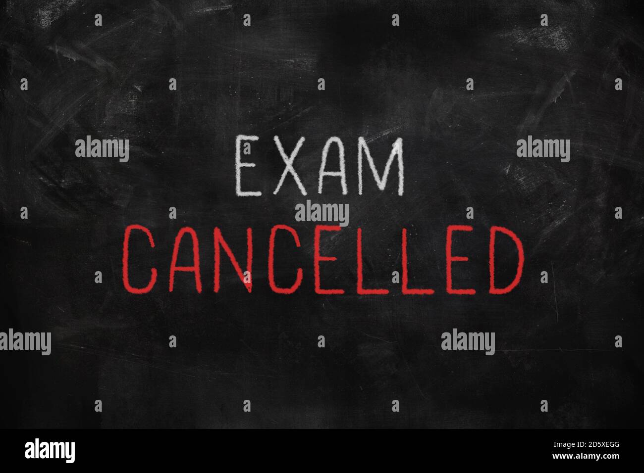 Exam cancelled written with white and red chalk on blackboard in classroom Foto Stock