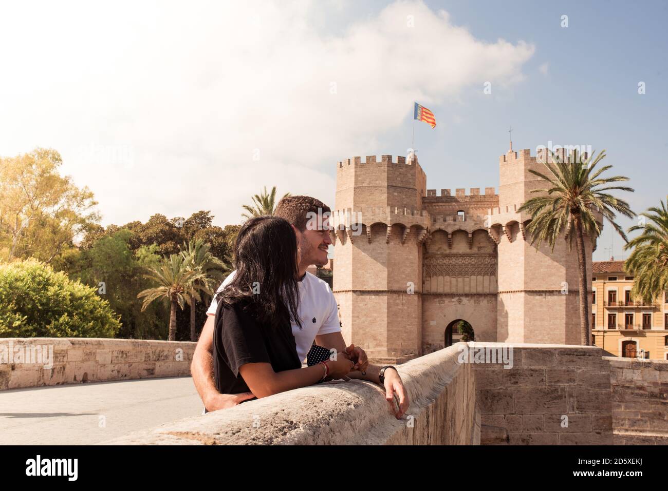 Attraente giovane coppia con porta Torres de Serranos sullo sfondo. Turisti a Valencia, Spagna. Foto Stock