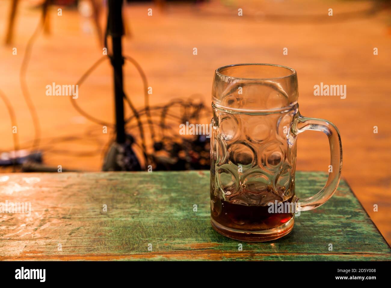 Germania - Monaco, Oktoberfest, boccale di birra sul tavolo di legno, attrezzatura palco in background Foto Stock