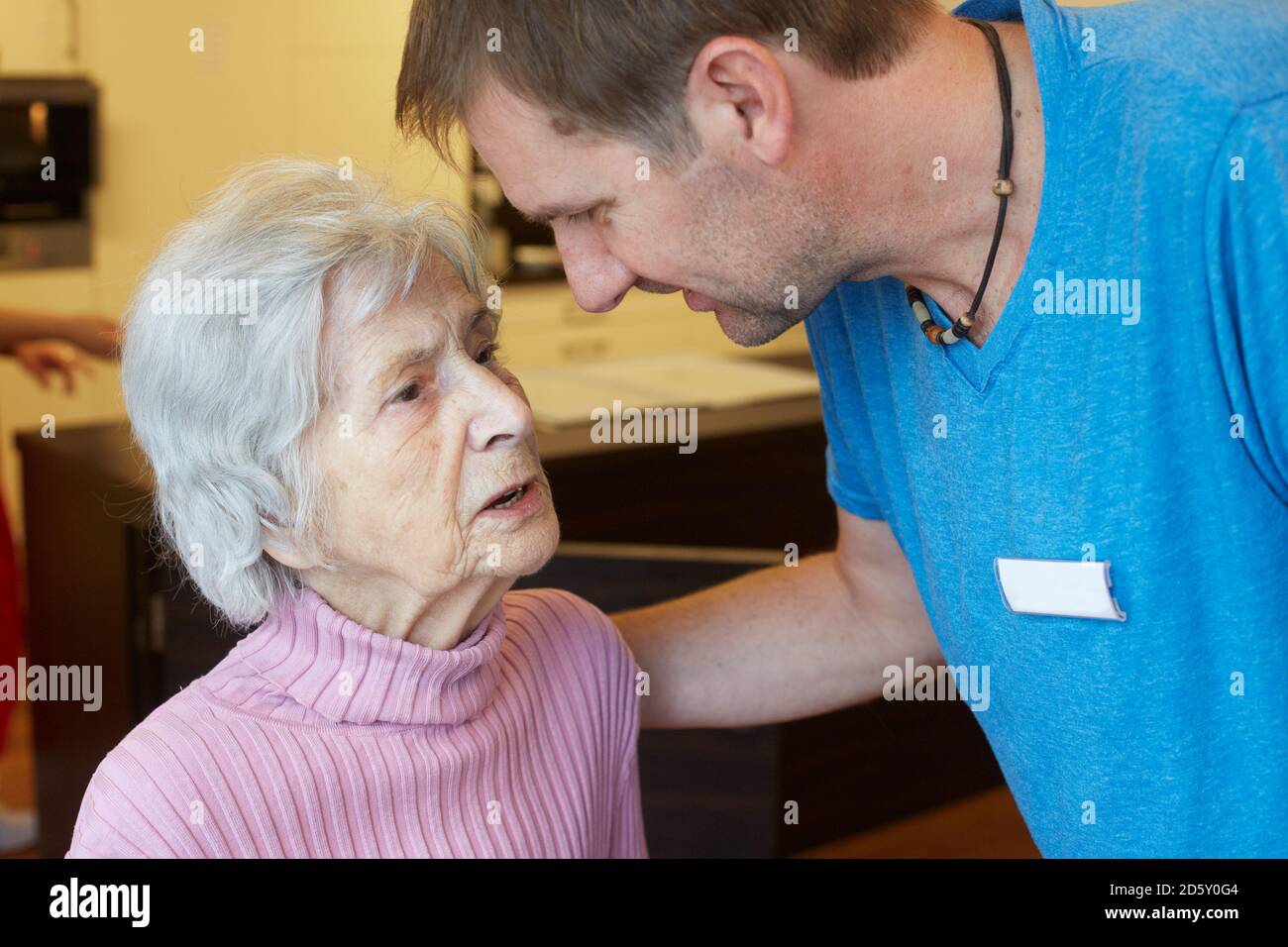 Infermiera geriatrica parlando di età senior demented donna in una casa di cura Foto Stock