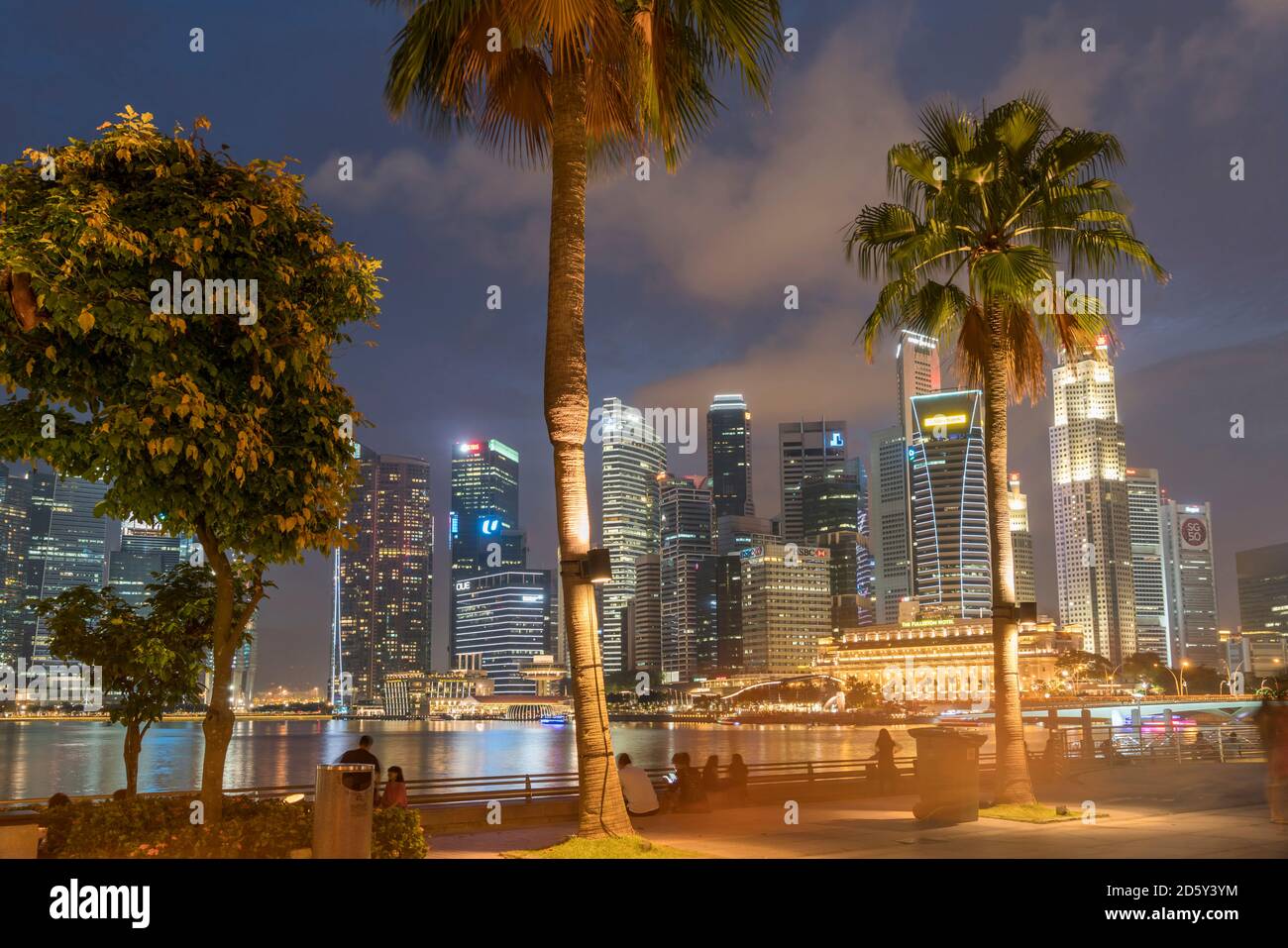 Singapore, Palme sul lungomare, Skyline al crepuscolo serale Foto Stock