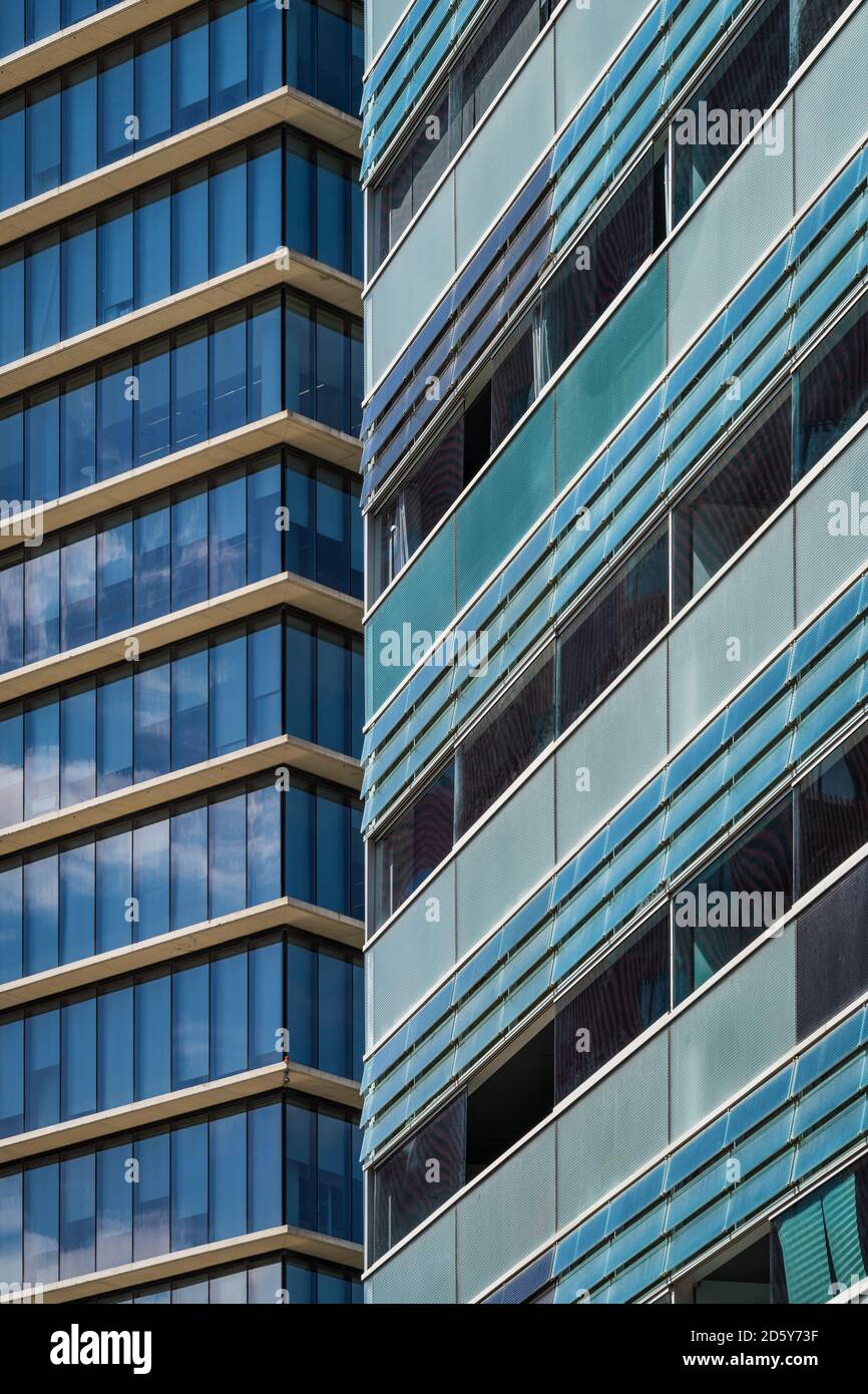 Balconi e finestre smaltate delle facciate di due città edifici in tonalità bluastre e verdastre Foto Stock