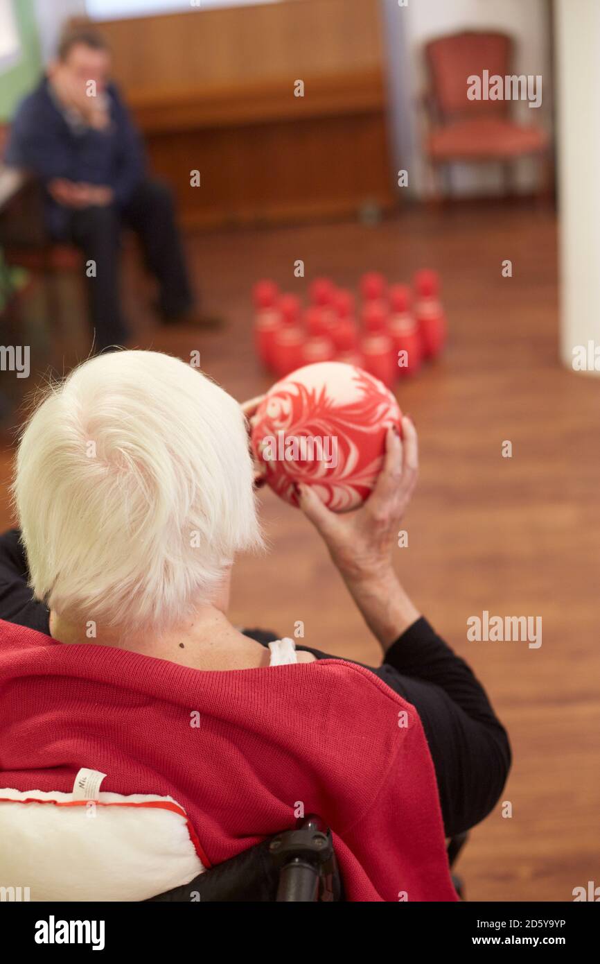Età demented donna senior bowling con schiuma palla in una casa di cura Foto Stock